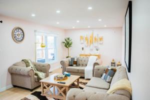 ein Wohnzimmer mit zwei Sofas und einem Tisch in der Unterkunft Riverfront Cottage Sauna Canoe Included Kids Playroom Nature Escape in Wasaga Beach