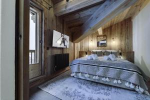 1 dormitorio con 1 cama en una pared de madera en Résidence La Charpenterie - Pièces 284, en La Rosière