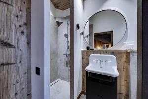 La salle de bains est pourvue d'un lavabo et d'un miroir. dans l'établissement Résidence La Charpenterie - Pièces 284, à La Rosière