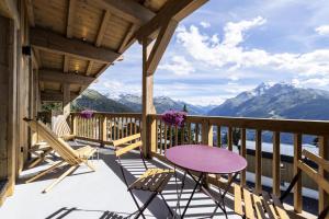 a porch with a table and chairs and mountains at Résidence La Charpenterie - Pièces 284 in La Rosière
