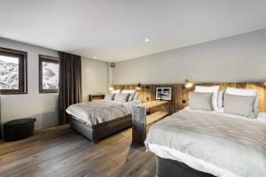 a hotel room with two beds and a couch at Chalet Quebec - Chalets pour 14 Personnes 454 in Saint-Martin-de-Belleville