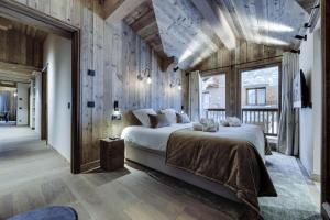 - une chambre avec un grand lit et des murs en bois dans l'établissement Résidence La Charpenterie - 4 Pièces pour 6 Personnes 344, à La Rosière