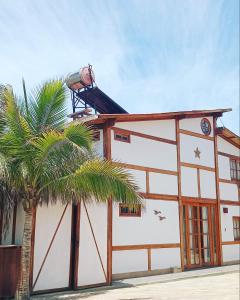 ein Gebäude mit einer Palme davor in der Unterkunft Kalua Plateritos in Plateritos