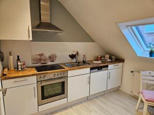 a kitchen with a sink and a stove at Ferienwohnung im Winkel in Hanstedt