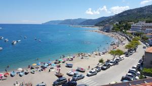 a beach with a crowd of people and boats in the water at La Casa di Aurelio in Capo dʼOrlando