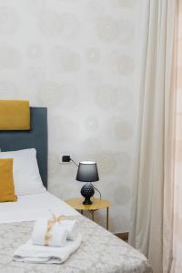 MarGab Guest House في نابولي: غرفة نوم بسرير وطاولة مع مصباح