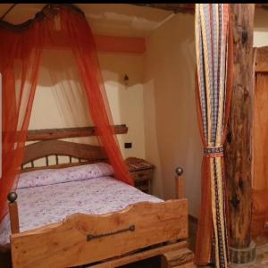 a bedroom with a wooden bed with a canopy at Agriturismo Radici Contadine in Bisaccia