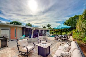 a patio with a couch and chairs and an umbrella at Lush Punta Gorda Escape Private Pool and Lanai in Punta Gorda