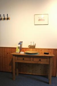 a wooden table with a plate on top of it at Ferienwohnung Struve Nr 2 in Petersdorf auf Fehmarn