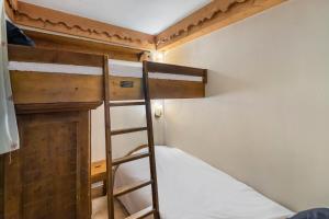 two bunk beds in a small room with a ladder at Résidence Ferm A - 3 Pièces pour 4 Personnes 204 in Les Allues