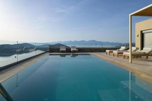 a swimming pool with a view of a house at Elounda Bright Villa in Elounda