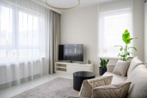 sala de estar blanca con sofá y TV en Apartament na Brodatego, en Varsovia