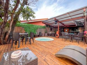 un patio con mesa y sillas en una terraza de madera en Bambú Lodge San Jose Airport, en Ciudad Cariari