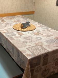 une table avec un tissu de table et deux tasses dessus dans l'établissement Casa a Cervinia sulle piste, à Breuil-Cervinia