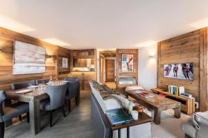 a living room with wooden walls and a dining room at Résidence Les Cimes Blanches - 4 Pièces pour 6 Personnes 414 in Courchevel