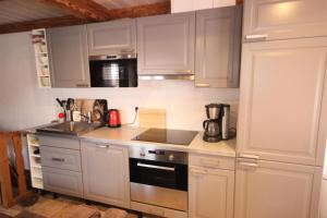 a kitchen with white cabinets and a stove top oven at Chalet Des Domaines De La Vanoise - Pièces 134 in Peisey-Nancroix