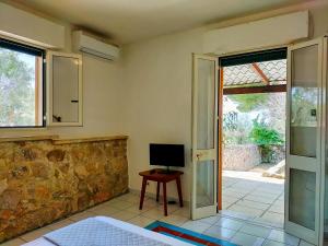 a room with a television and a door to a patio at Residence Mariposa - Apartments & Rooms in Salve