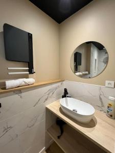 een badkamer met een wastafel en een spiegel bij L’émeraude : vue mer - MALO’Cation in Duinkerke