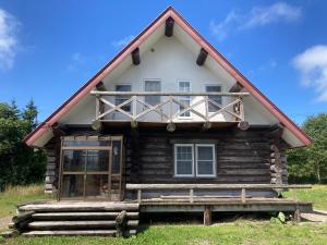 eine Blockhütte mit einem großen Fenster und einer Veranda in der Unterkunft Mashuko Youth Hostel - Vacation STAY 01024v in Teshikaga