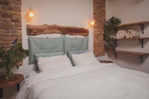 een slaapkamer met een wit bed en een houten hoofdeinde bij חלון לגלבוע צימר בוטיק בעמק המעיינות in Bet Alfa