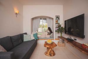 - un salon avec un canapé et une fenêtre pour une femme dans l'établissement חלון לגלבוע צימר בוטיק בעמק המעיינות, à Bet Alfa