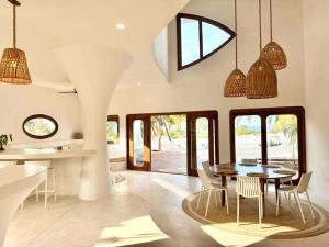 cocina y comedor con mesa y sillas en Unique Beachfront Casa Kyma, Pool, San Crisanto, Yucatan, en San Crisanto