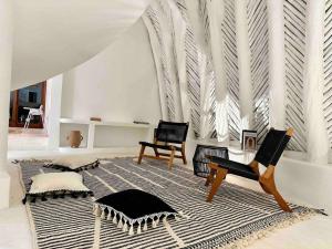 a living room with two chairs and a rug at Unique Beachfront Casa Kyma, Pool, San Crisanto, Yucatan in San Crisanto