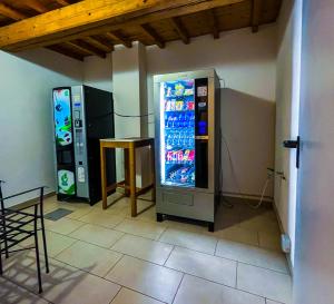 two vending machines are sitting next to a table at House Brennero 29 in Carpi