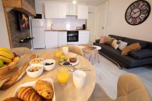 a living room with a table with breakfast foods on it at Le Nid 3 étoiles Wifi, Netflix, Disney, Coeur de Bastide in Villefranche-de-Rouergue