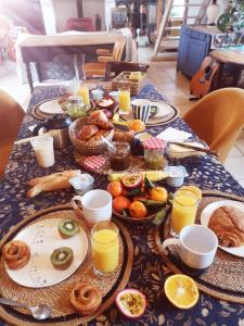 une table recouverte de assiettes de nourriture et de jus d'orange dans l'établissement La ferme du tilleul, à Conchy-les-Pots