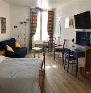 ein Wohnzimmer mit einem Bett, einem Tisch und Stühlen in der Unterkunft Location cure ou vacances dans maison charentaise centre ville in Saujon