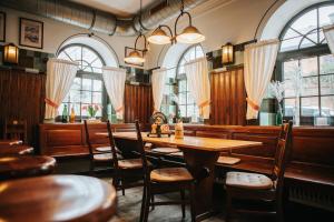 a restaurant with wooden tables and chairs and windows at Unertl Bräustüberl Gästehaus in Haag in Oberbayern