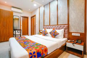 a bedroom with a large bed with a colorful blanket at Hotel Affari in Mumbai