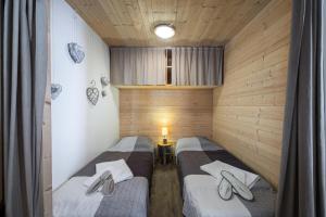 2 Einzelbetten in einem Zimmer mit Holzwänden in der Unterkunft Résidence Roc De Peclet 2 - Studio pour 4 Personnes 414 in Val Thorens