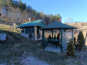 a gazebo with a picnic table in a yard at Odmor u Komaranima in Nova Varoš