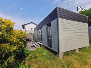 a black and grey tiny house on a grass field at DM DOMKI Kościelna 54 in Mielno