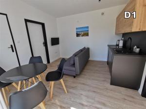 a kitchen and a living room with a table and chairs at DM DOMKI Kościelna 54 in Mielno