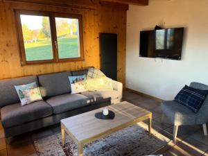 a living room with a couch and a table and a tv at Résidence Le Cristal - Chalets pour 8 Personnes 154 in Crest-Voland