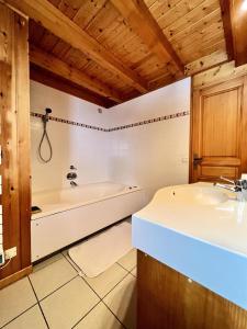 a bathroom with a sink and a bath tub at Résidence Le Cristal - Chalets pour 8 Personnes 154 in Crest-Voland
