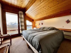 a bedroom with a bed and a large window at Résidence Le Cristal - Chalets pour 8 Personnes 154 in Crest-Voland