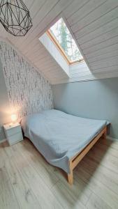 a bedroom with a bed in a attic with a window at Fiszka in Pobierowo