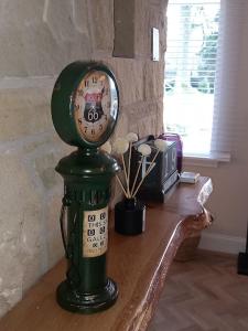 a clock sitting on a table next to a window at Beautiful Historic Cottage in Callander +10 photos
