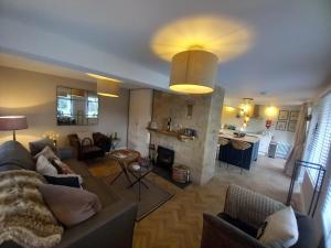 a living room with a couch and a kitchen at Beautiful Historic Cottage in Callander