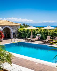 科羅尼的住宿－LIOKRINA country living villas & suites，一个带椅子和遮阳伞的游泳池