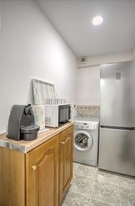 a kitchen with a refrigerator and a washer and dryer at Cantinho a Sul II - Costa Nova in Gafanha da Encarnação