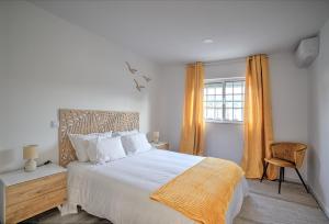 a bedroom with a large white bed and a window at Cantinho a Sul II - Costa Nova in Gafanha da Encarnação