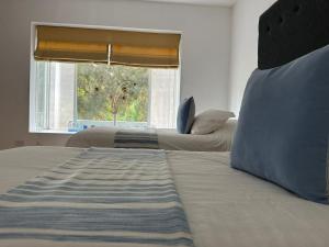 2 camas en un dormitorio con ventana en Hotel Los Palomos, en Lunahuaná