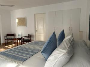 a bedroom with a large bed with blue pillows at Hotel Los Palomos in Lunahuaná