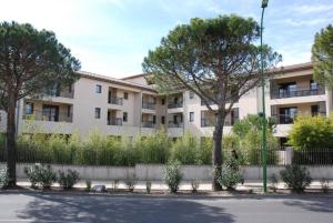 an apartment building with trees in front of it at Propriete de 2 chambres avec piscine partagee terrasse et wifi a Uzes in Uzès