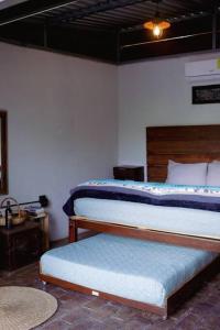 1 dormitorio con 2 camas y mesa con banco en cabaña las chachalacas,hermoso espacio natural en Colima